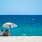 people sitting under an umbrella on a beach
